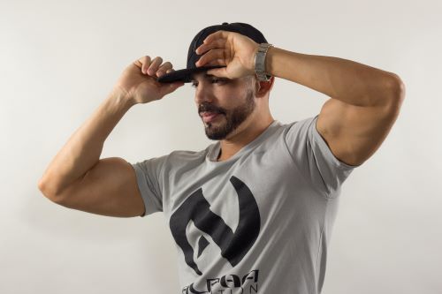 Streetwear Hat Trends. Man Touching The Brim Of His Hat On His Head.